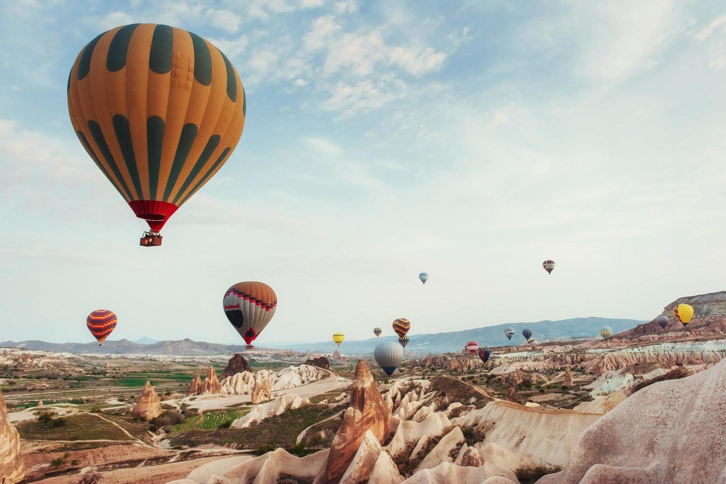 Heißluftballon, der über Felsenlandschaft am Kappadokien-Truthahn fliegt. foto