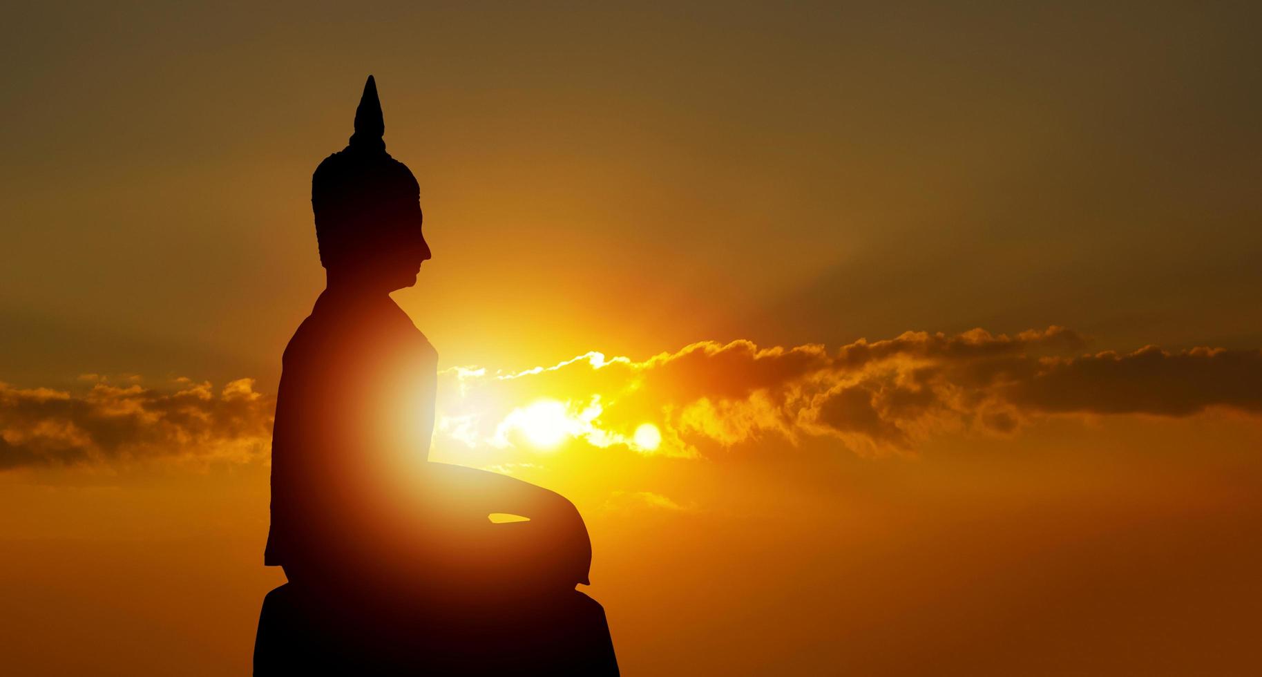 Buddha-Silhouette auf goldenem Sonnenuntergang Hintergrund Überzeugungen des Buddhismus foto