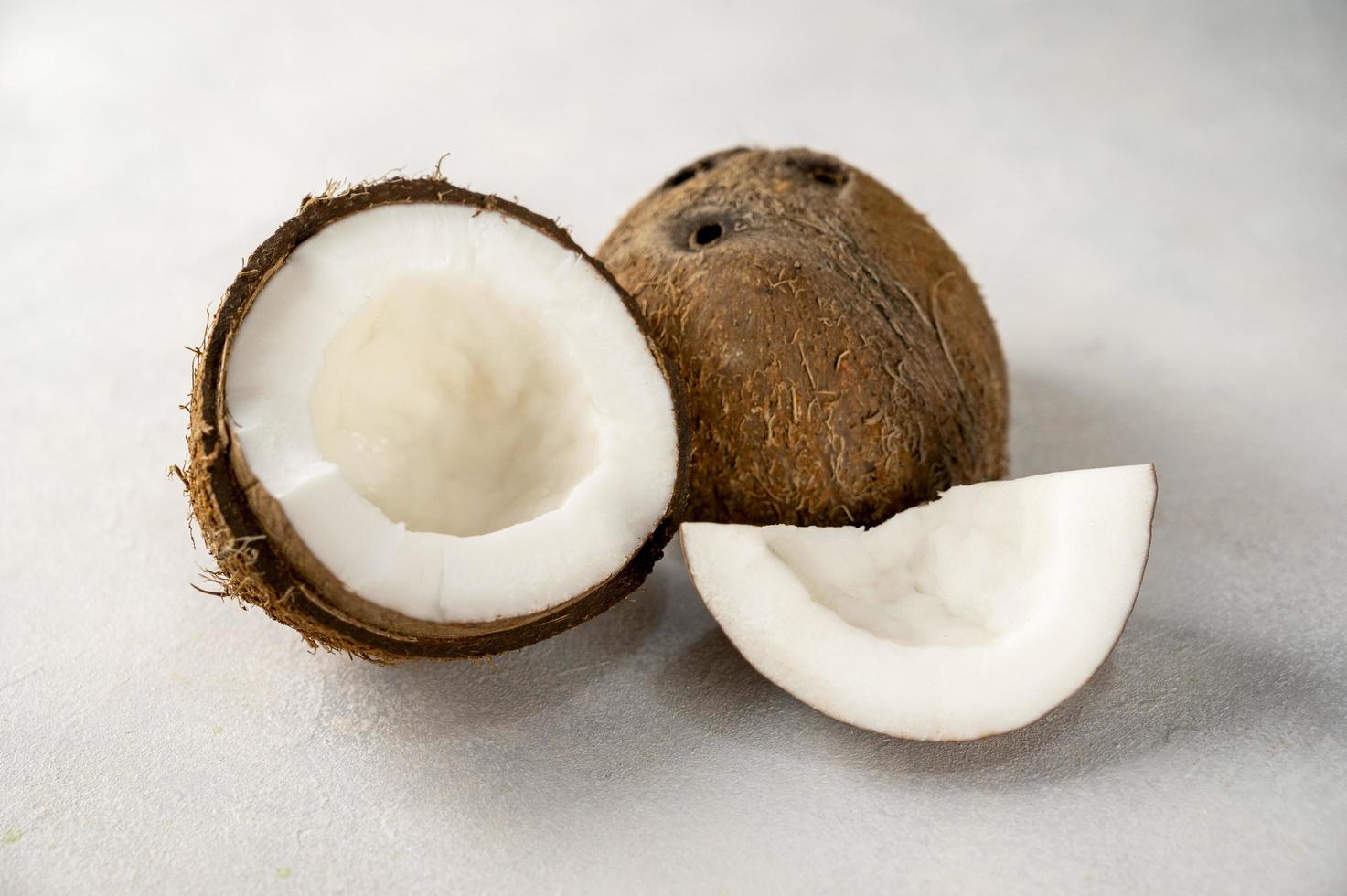 frische nussfruchtstücke der kokosnuss auf hellem hintergrund foto