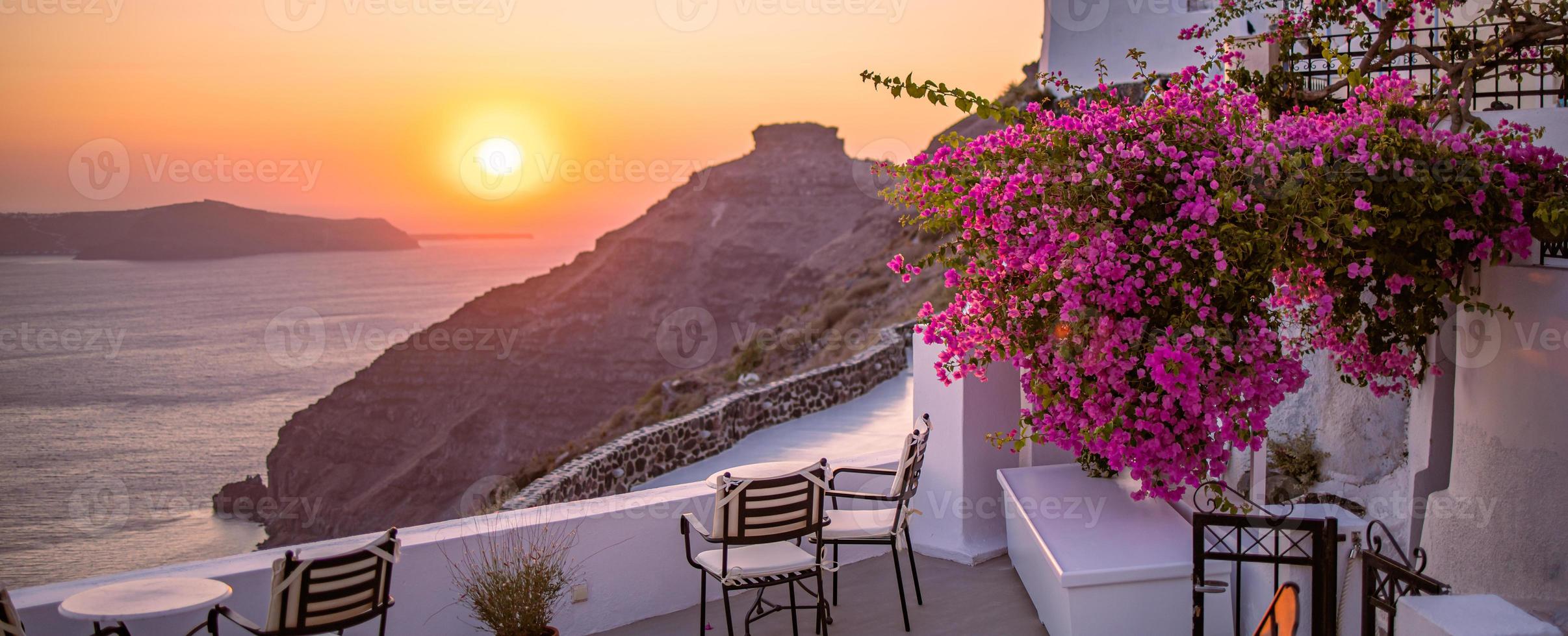 schöne aussicht auf die caldera und genießen der romantischen landschaft sonnenuntergang ägäis, santorini. paar reisen urlaub, flitterwochenziel. Romantik mit Blumen, zwei Stühlen Tisch und Meerblick. Luxuriöser Urlaub foto