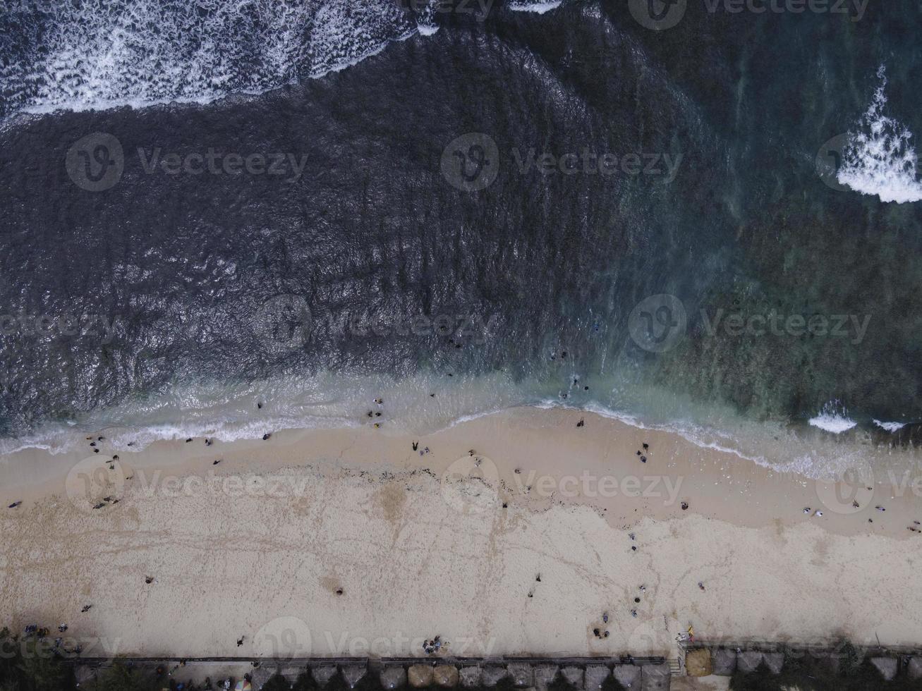 luftdrohnenansicht des urlaubs in gunung kidul beach, indonesien mit ozean, booten, strand und menschen. foto