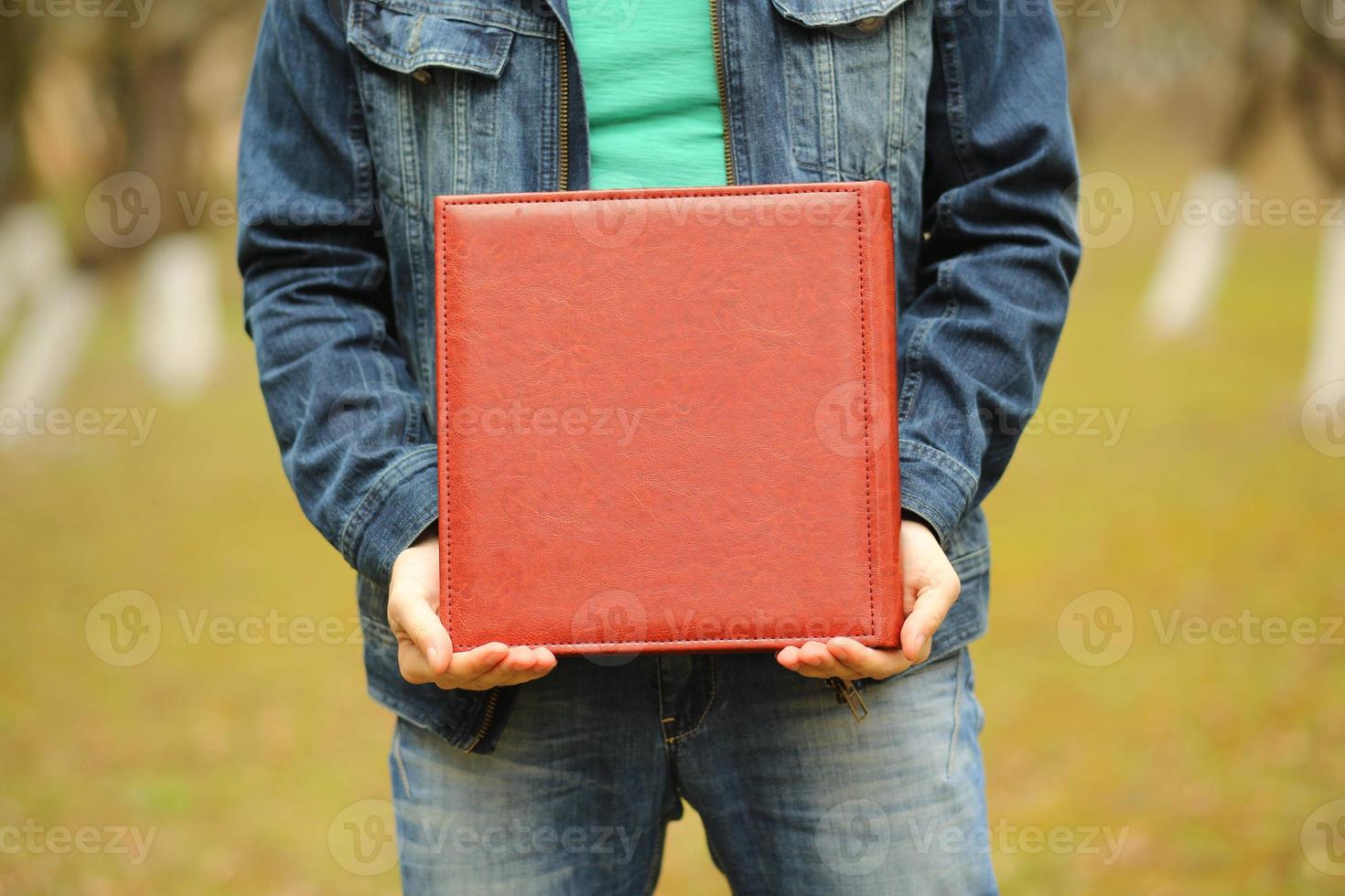 quadratisches Fotobuch in seinen Händen. Hochzeitsfotoalbum foto