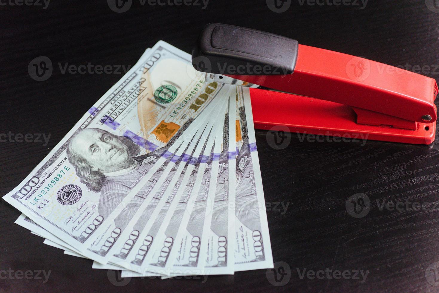 Dollar und Hefter auf schwarzem Hintergrund foto