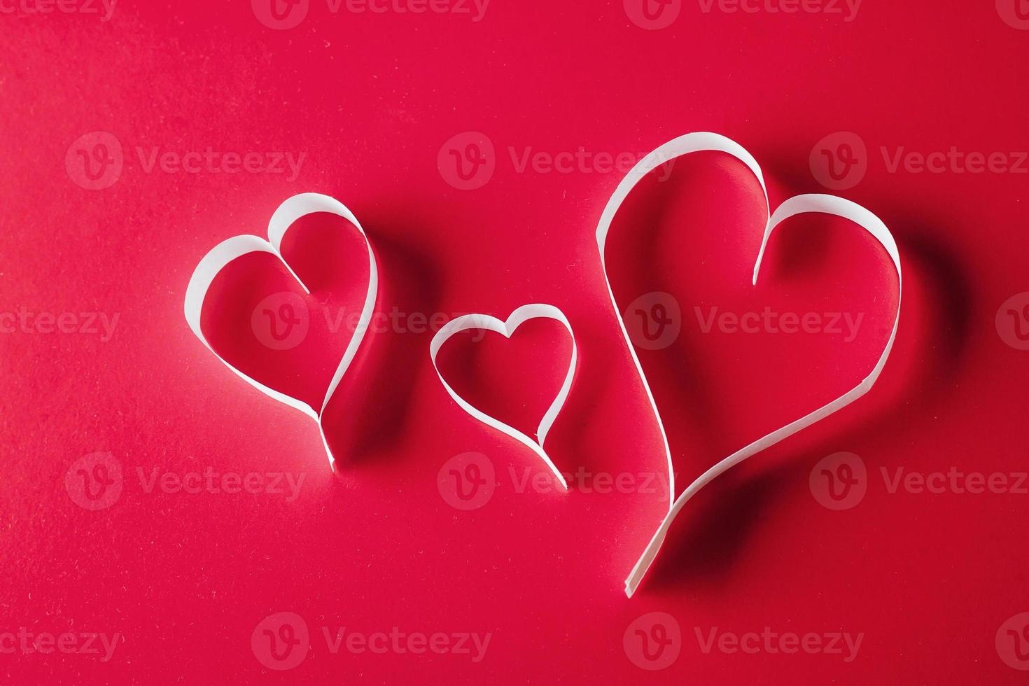 Urlaubskarte. Herz zum Valentinstag. weiße Herzen auf einem roten Ba foto