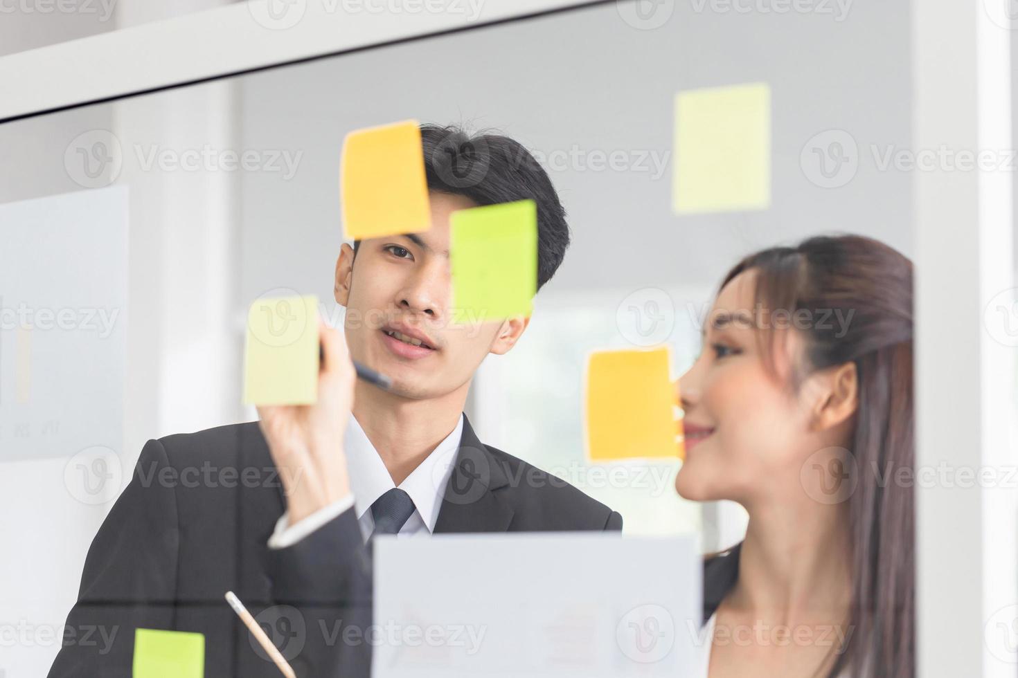 junge geschäftsleute treffen sich im büro und verwenden post-it-notizen, um ideen auszutauschen. büroangestellte diskutieren gemeinsam im konferenzraum foto