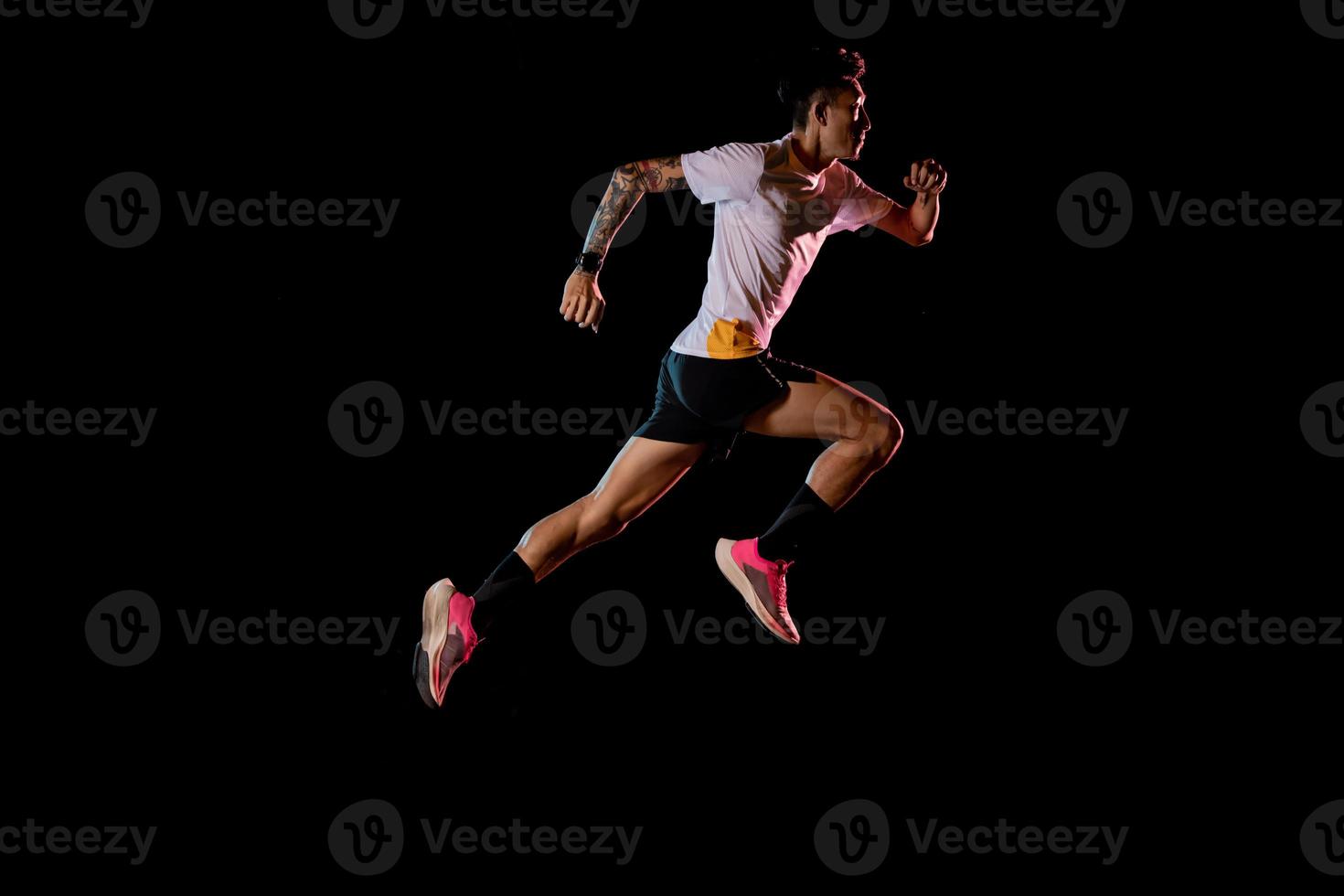 asiatischer Mann junger Sprinter läuft im Studio auf schwarzem Hintergrund foto