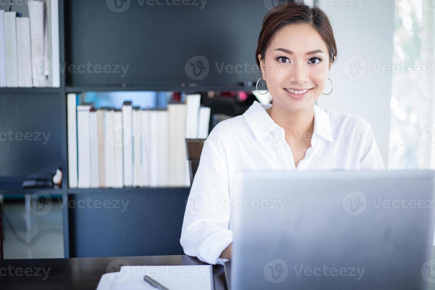 schöne asiatische geschäftsfrauen, die dokument überprüfen und notizbuch verwenden und glücklich für die arbeit lächeln foto