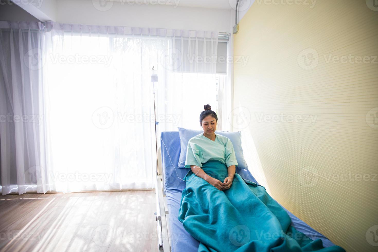 Patientin sitzt auf einem Arzt, der in Krankenhäusern im Bett liegt foto
