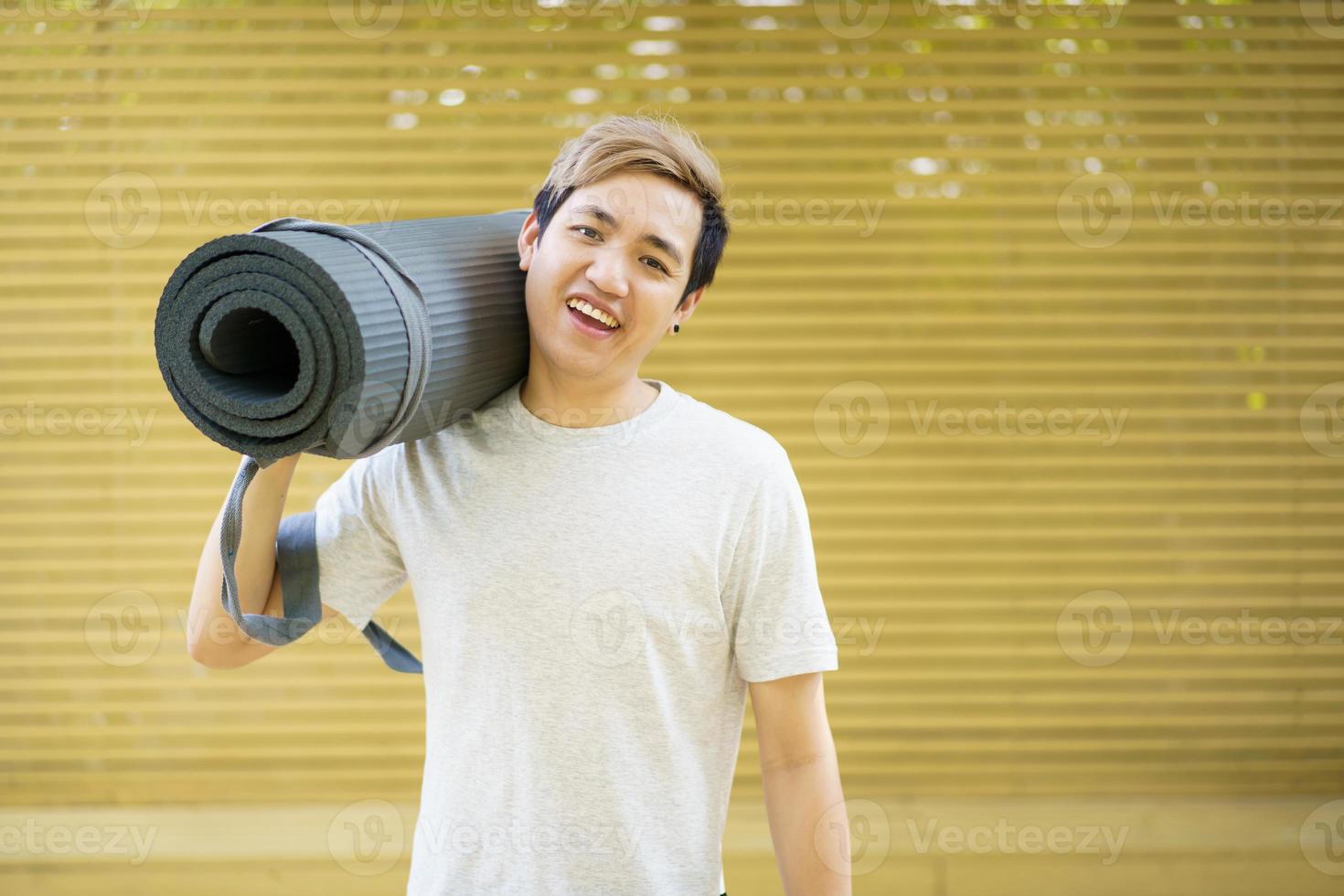 Mann, der eine Yogamatte für Körpergewichtsübungen vorbereitet. foto