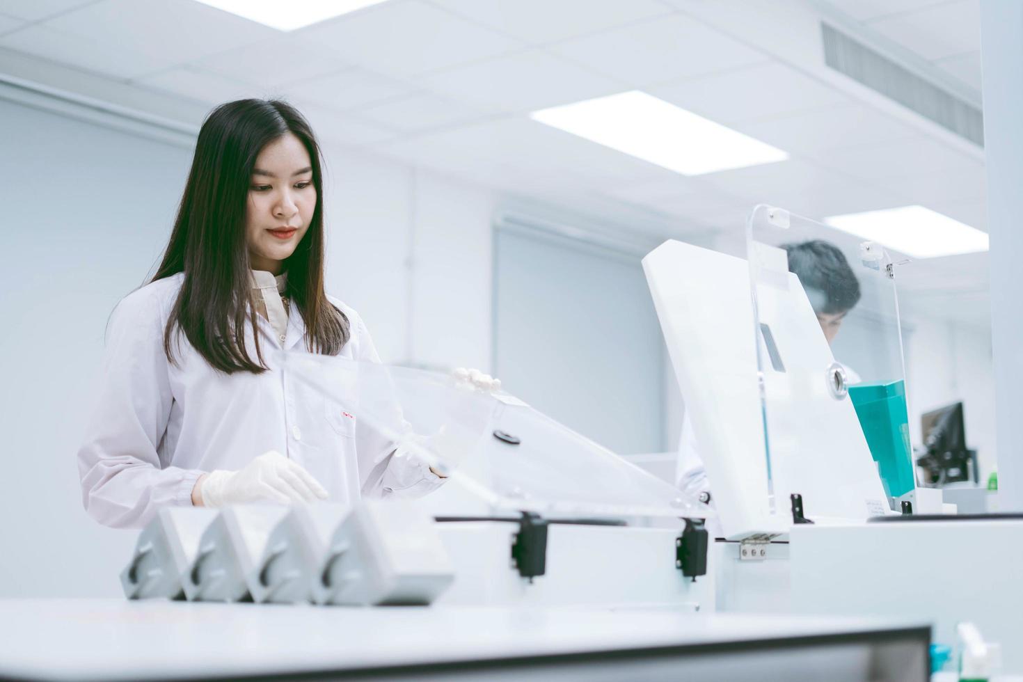 Junge Wissenschaftlerinnen öffnen die Zentrifuge im medizinischen Labor foto