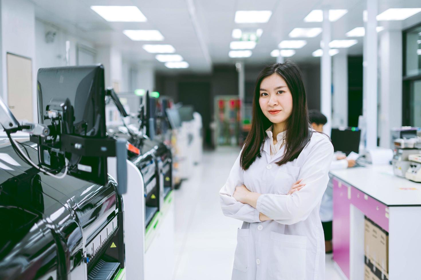 junge wissenschaftlerin, die mit einem automatisierten blutanalysatorbericht im medizinischen labor arbeitet foto