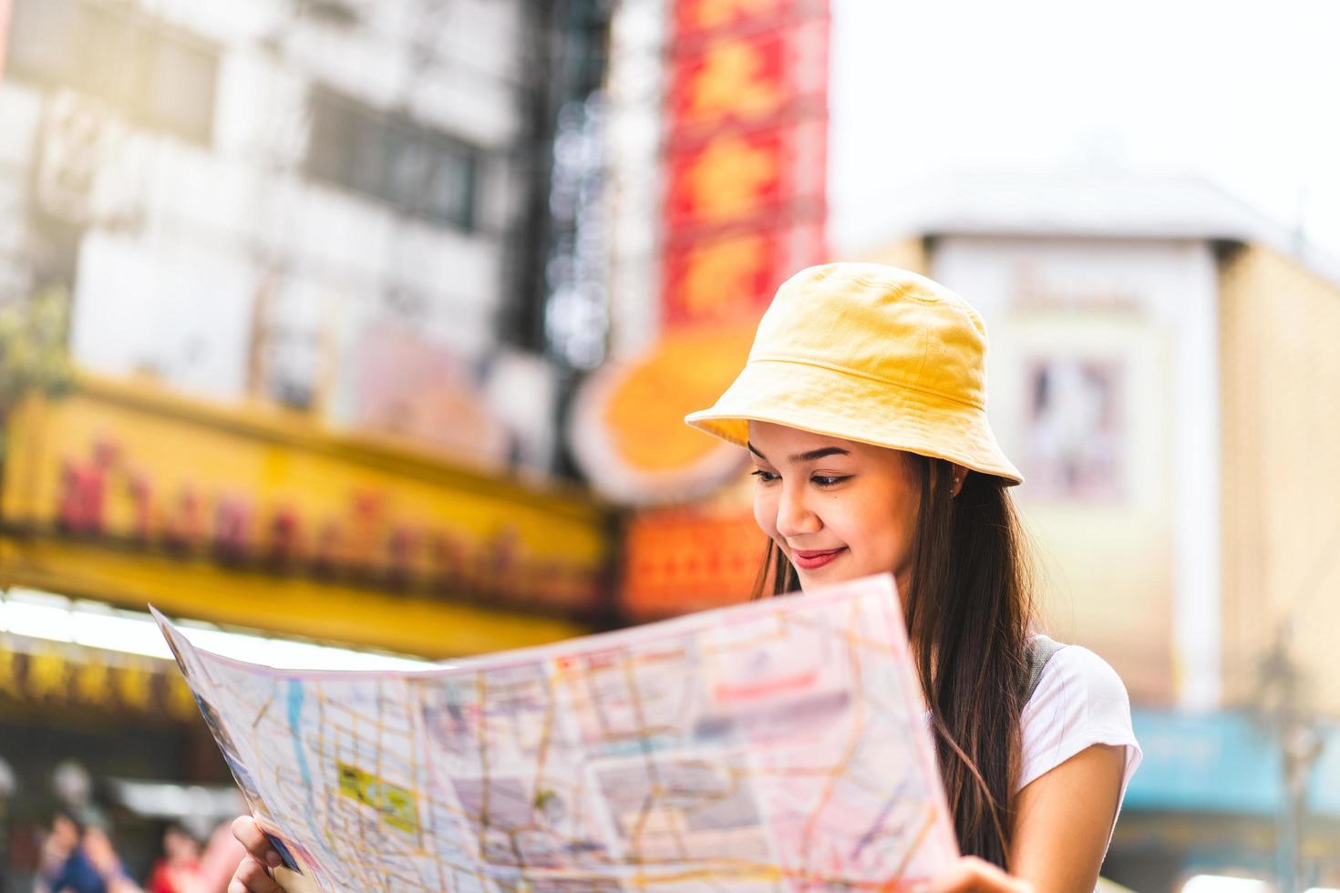 asiatische frau, die mit karte in chinatown sucht foto