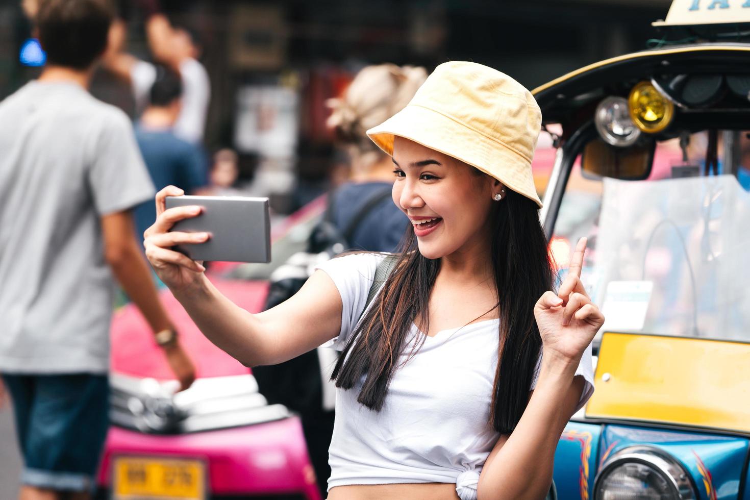 asiatischer reisender glückliche frau selfie mit tuktuk-taxi im thailändischen stil. foto