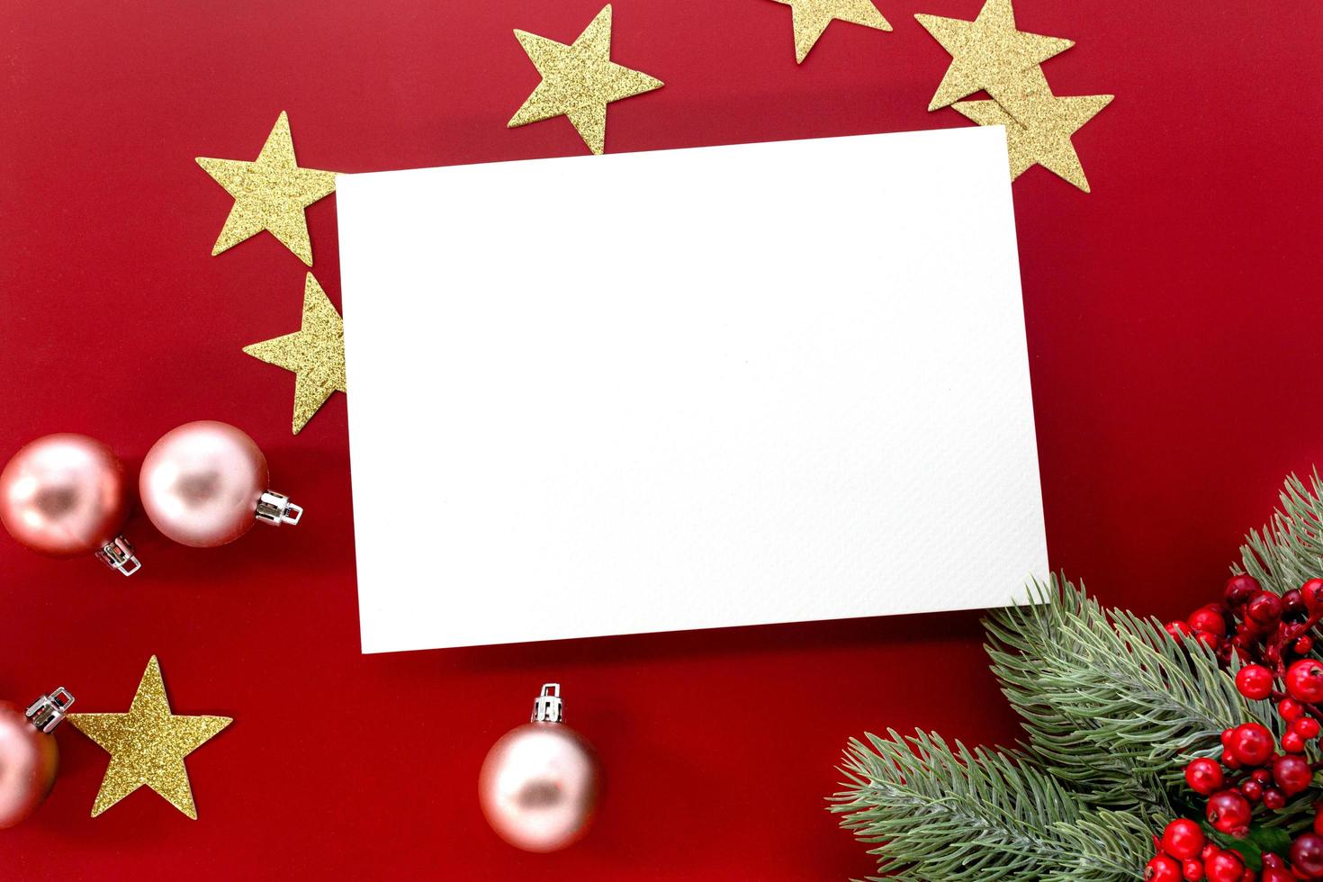 weihnachtsmodell, glitzernde sterne und ornamente mit leerer karte für kopierraum auf rotem hintergrund. foto