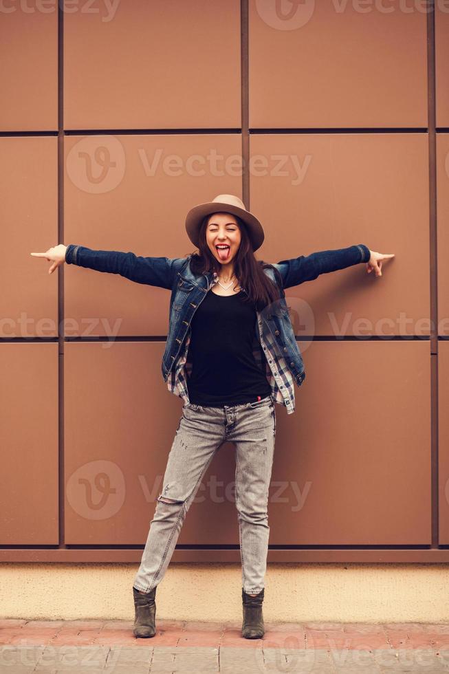 emotionales Mädchen steht in der Nähe einer Wand foto