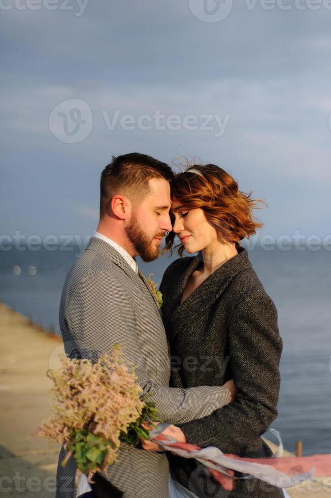 Hochzeitsfotosession eines Paares an der Küste. blaues hochzeitskleid an der braut. foto