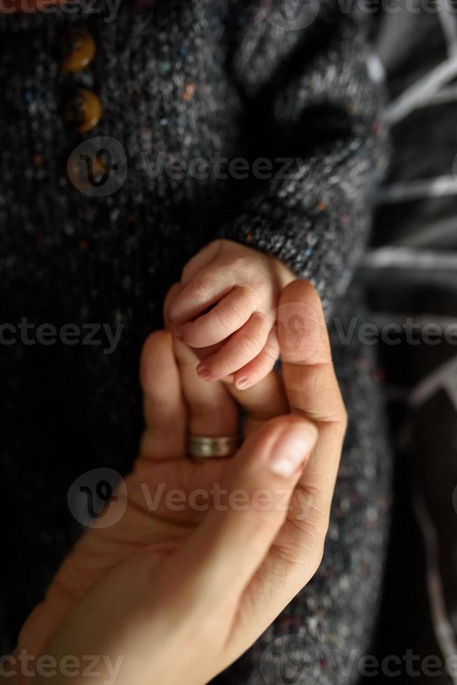 Mutter hält die kleine Hand ihres neugeborenen Sohnes. foto