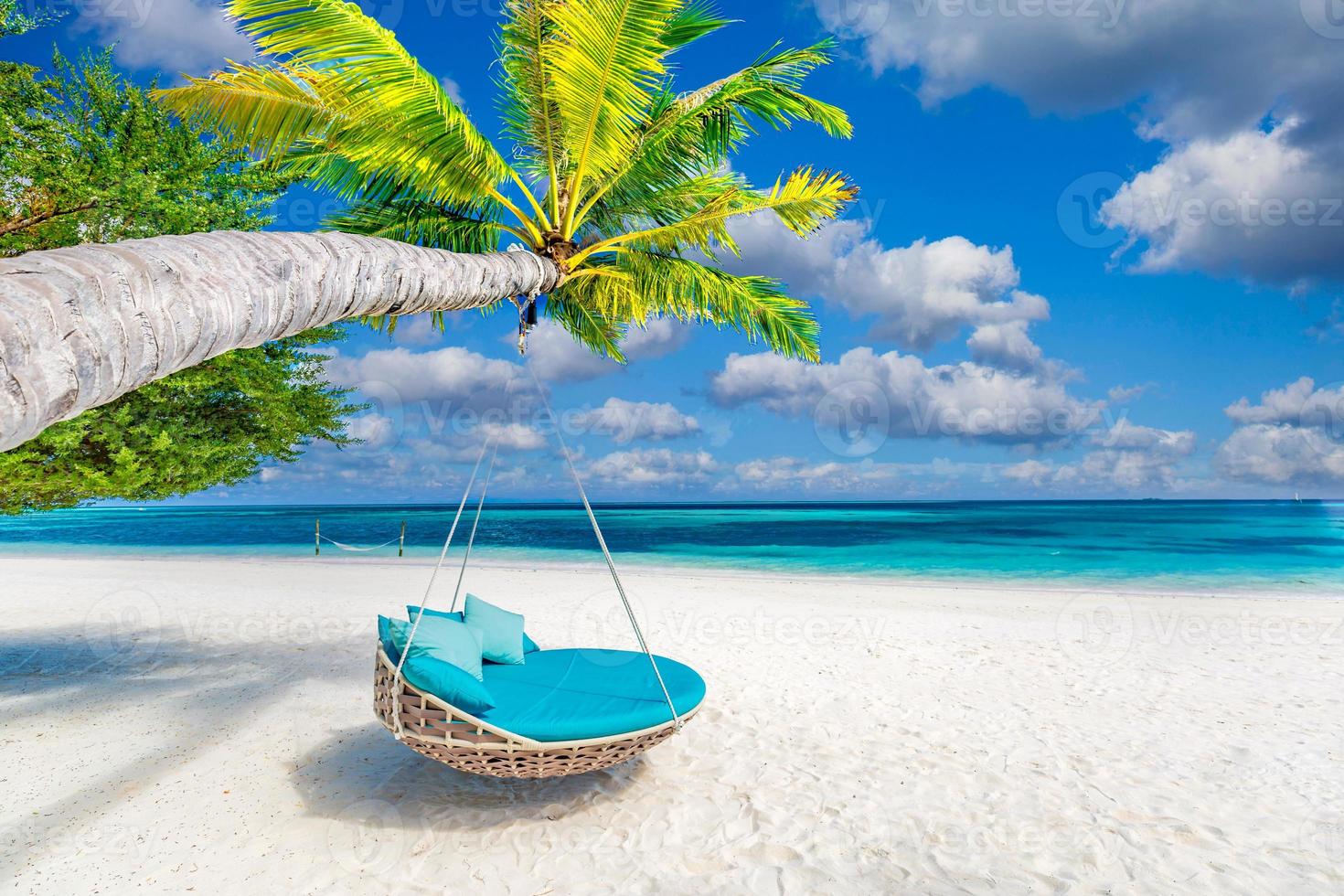 tropischer strandhintergrund als sommerlandschaft mit strandschaukel oder hängematte und weißem sand und ruhigem meer für strandbanner. perfektes strandszenenurlaubs- und sommerferienkonzept. Verbessern Sie den Farbprozess foto