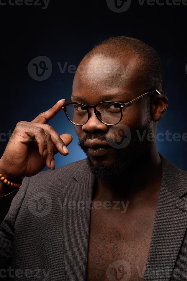 Ein schwarzer Afroamerikaner singt emotional in ein Mikrofon. Nahaufnahme Studioporträt. foto