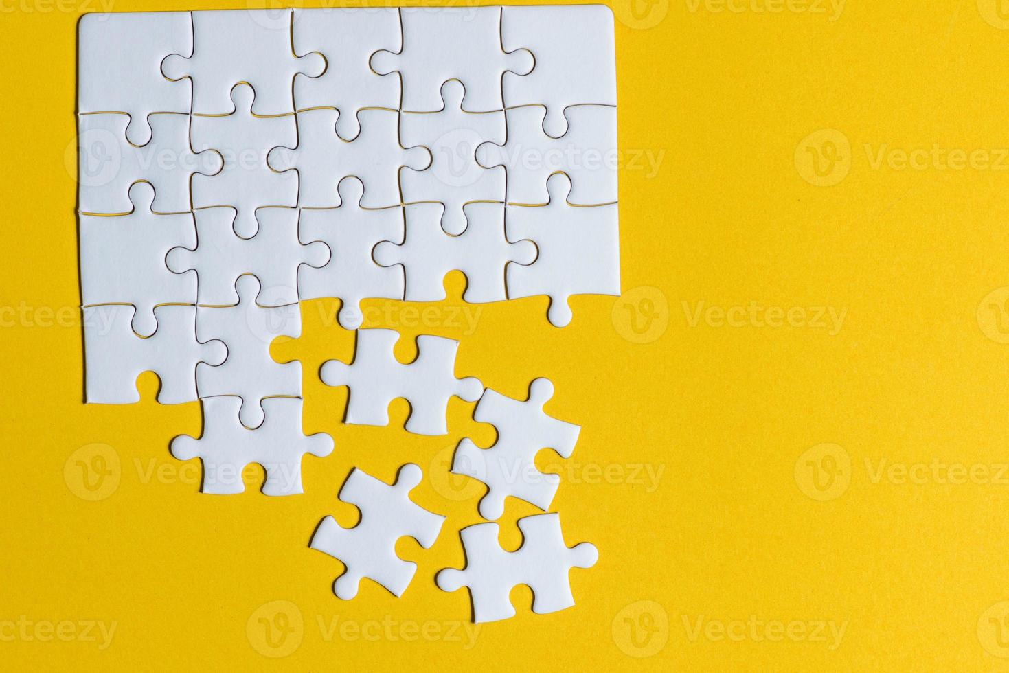 Puzzles platziert auf einem kreativen Konzept mit gelbem Hintergrund und Kopierraum foto