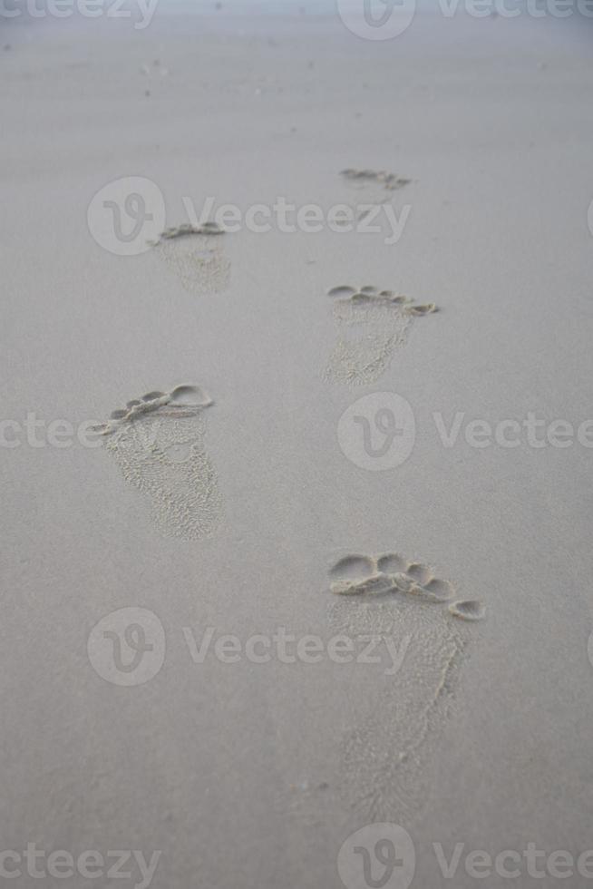 Fußspuren am Sandstrand von Rayong in Thailand foto