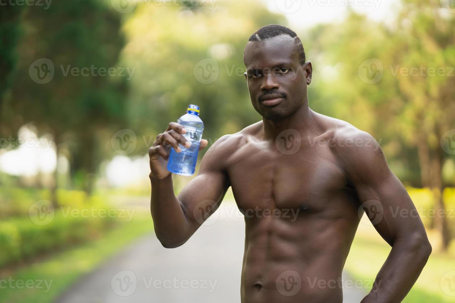 Attraktiver afrikanischer Sportler müde und durstig nach laufendem Training Trinkwasser. Sport Mann Konzept foto