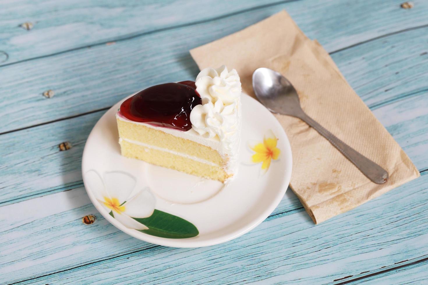 Heidelbeer-Käsekuchen auf dem blauen Tisch hausgemachtes Dessert mit Löffel und Seidenpapier foto