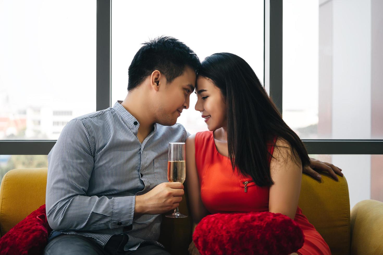 Junges erwachsenes asiatisches Liebespaar Mann und Frau halten ein Glas Champagner in der Hand foto