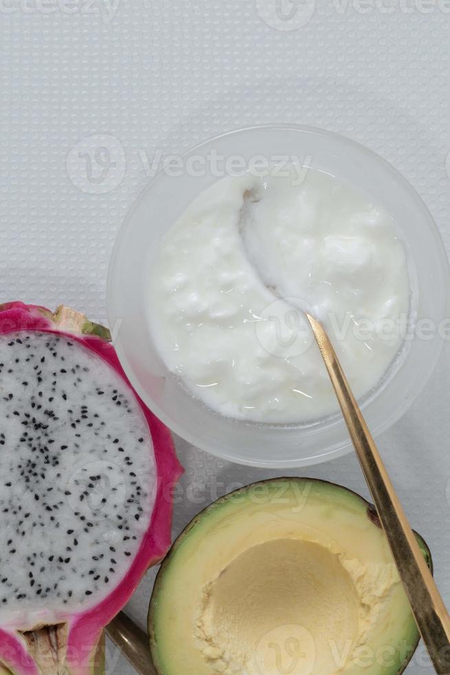 gesunder lebensmitteljoghurt in der schüssel hat frucht auf weißem tisch. foto