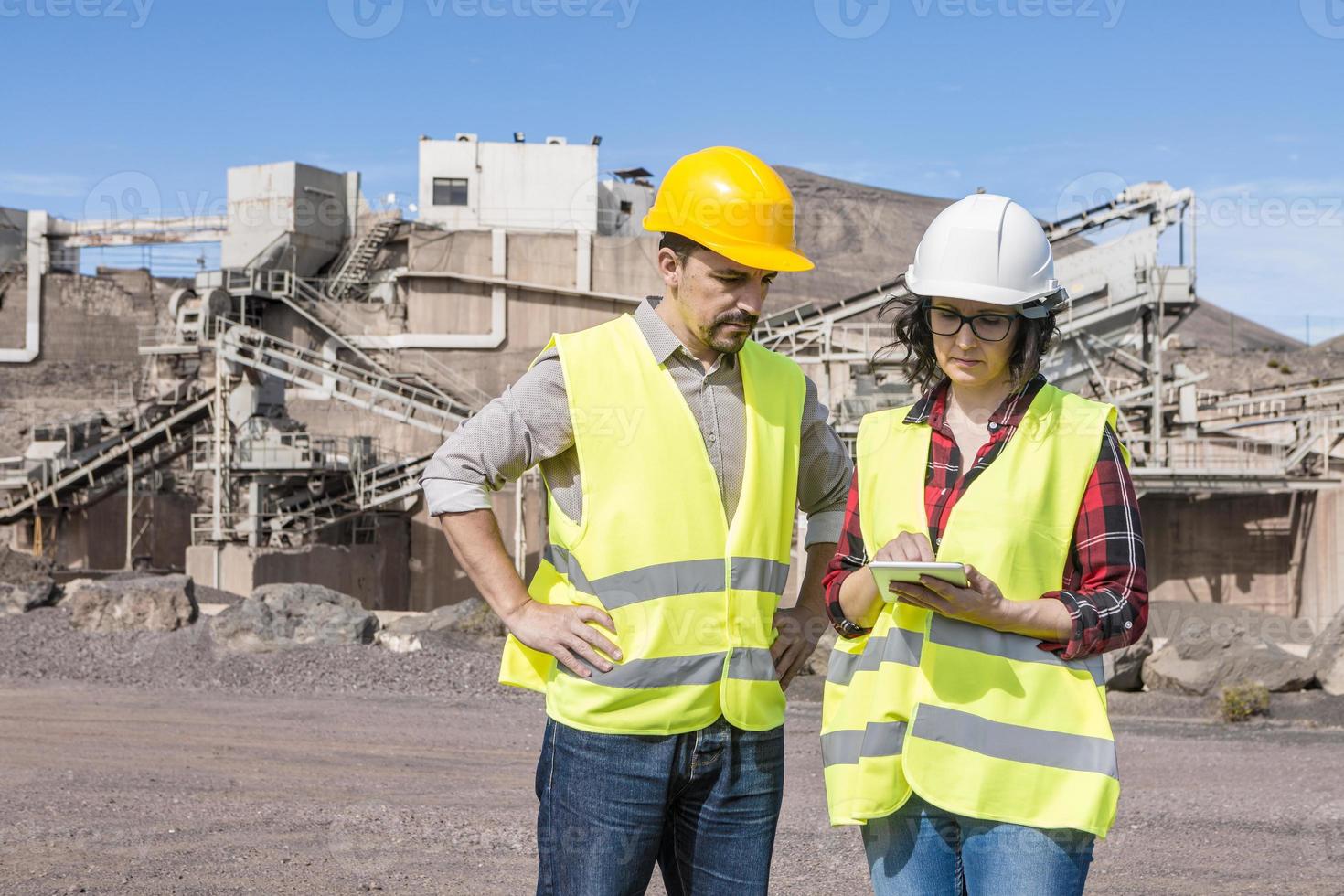 Ingenieure mit Tablet kommunizieren auf der Baustelle foto