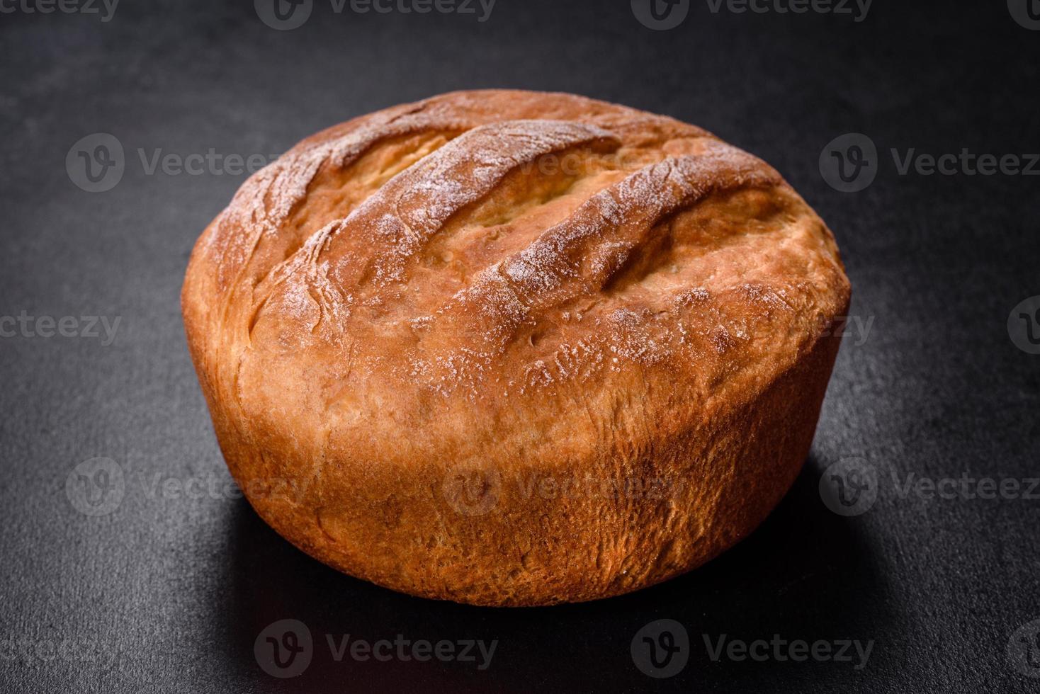 Leckeres frisch gebackenes Weißbrot im Ofen auf dunklem Betonhintergrund foto