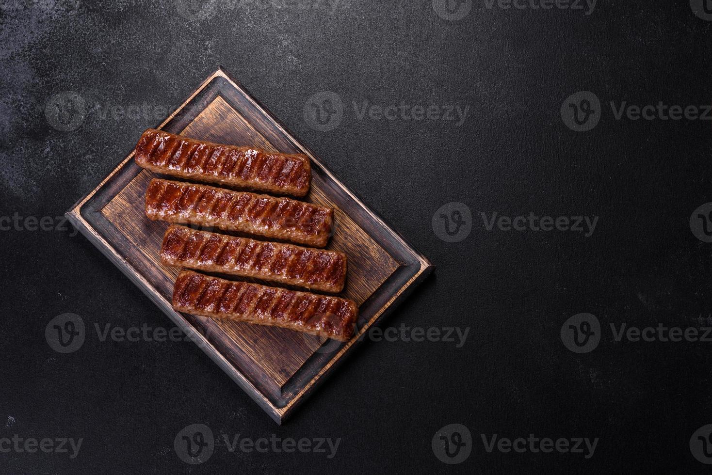 gegrillter kebab mit gewürzen und kräutern auf dunklem betonhintergrund foto