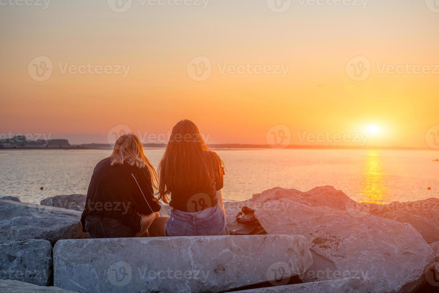 Mädchen umarmten sich bei Sonnenuntergang foto