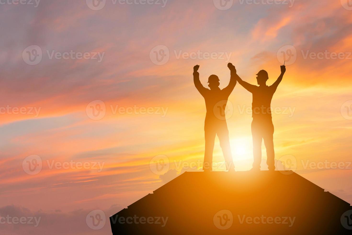 Schattenbild des Wirtschaftsingenieurmannes mit Beschneidungspfadfeiererfolgsglück auf Behälterkastenabendhimmel-Sonnenunterganghintergrund, Teamwork-Konzept foto