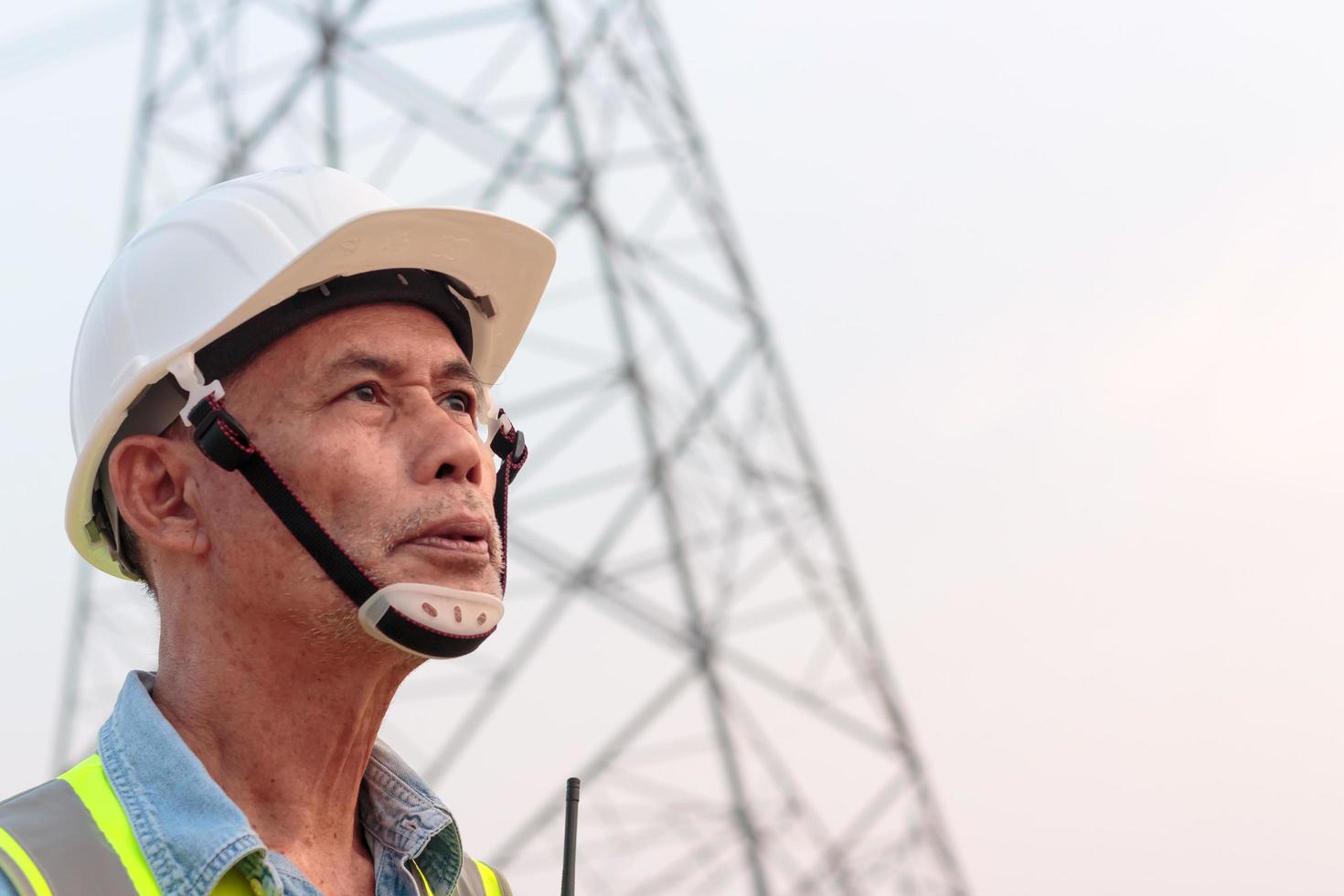 ein Ingenieur mittleren Alters mit Schutzhelm auf einer Baustelle, ein asiatischer Ältester. foto