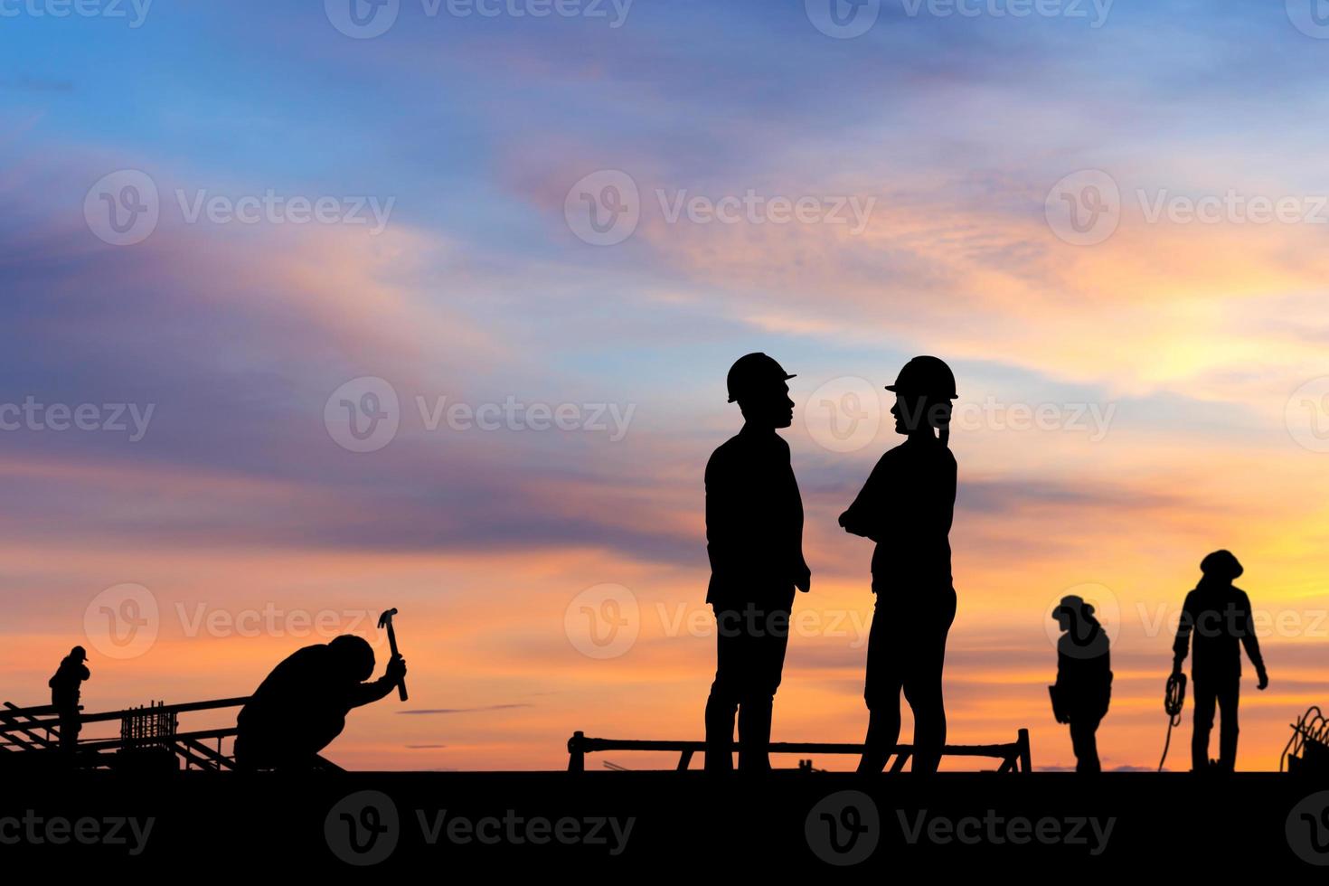 Silhouette von Ingenieur und Arbeiter auf der Baustelle, Baustelle bei Sonnenuntergang am Abend foto