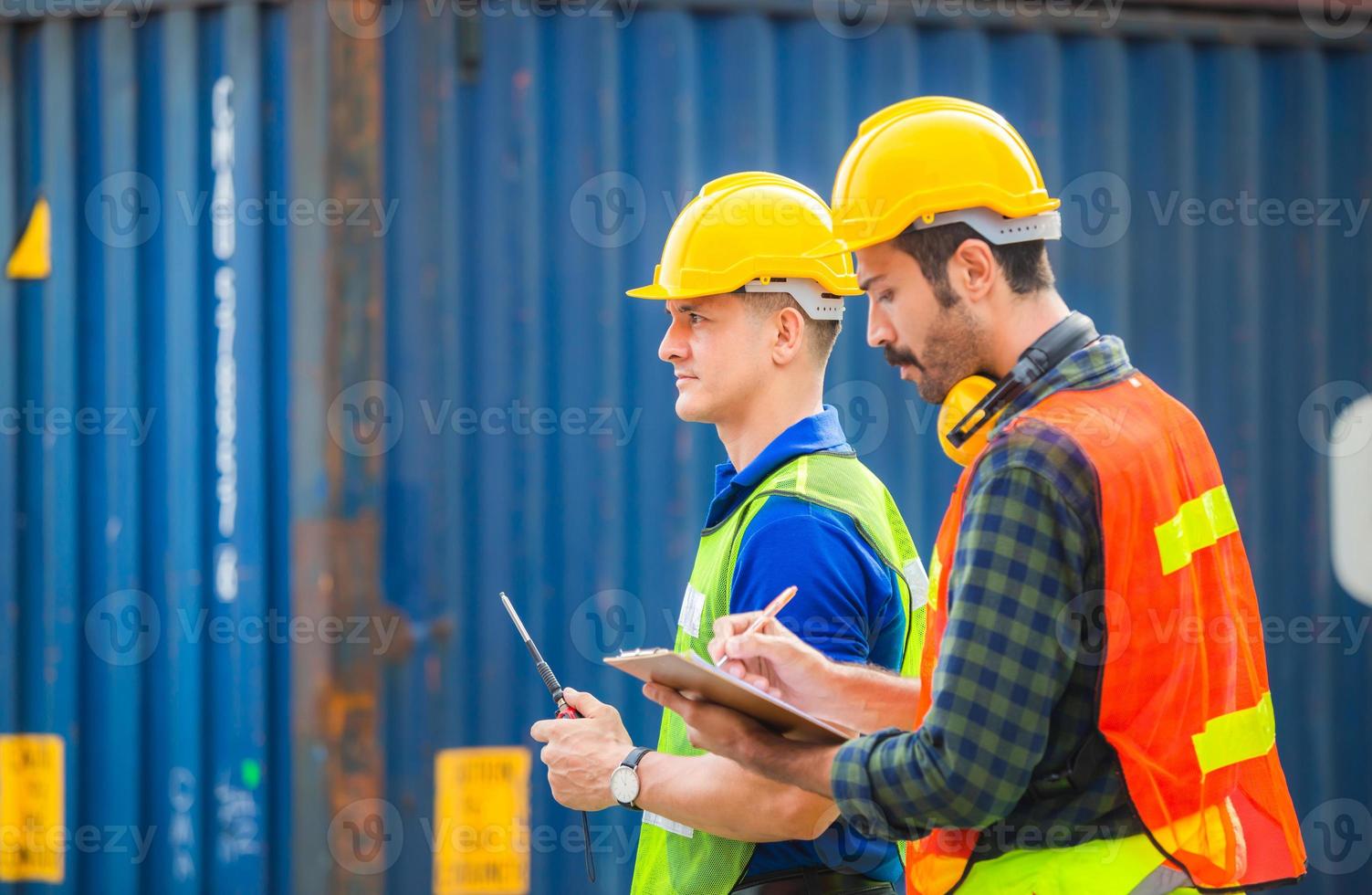 ingenieur- und arbeiterteam überprüfen container aus der fracht mit verschwommenem hintergrund, teamwork-konzept foto