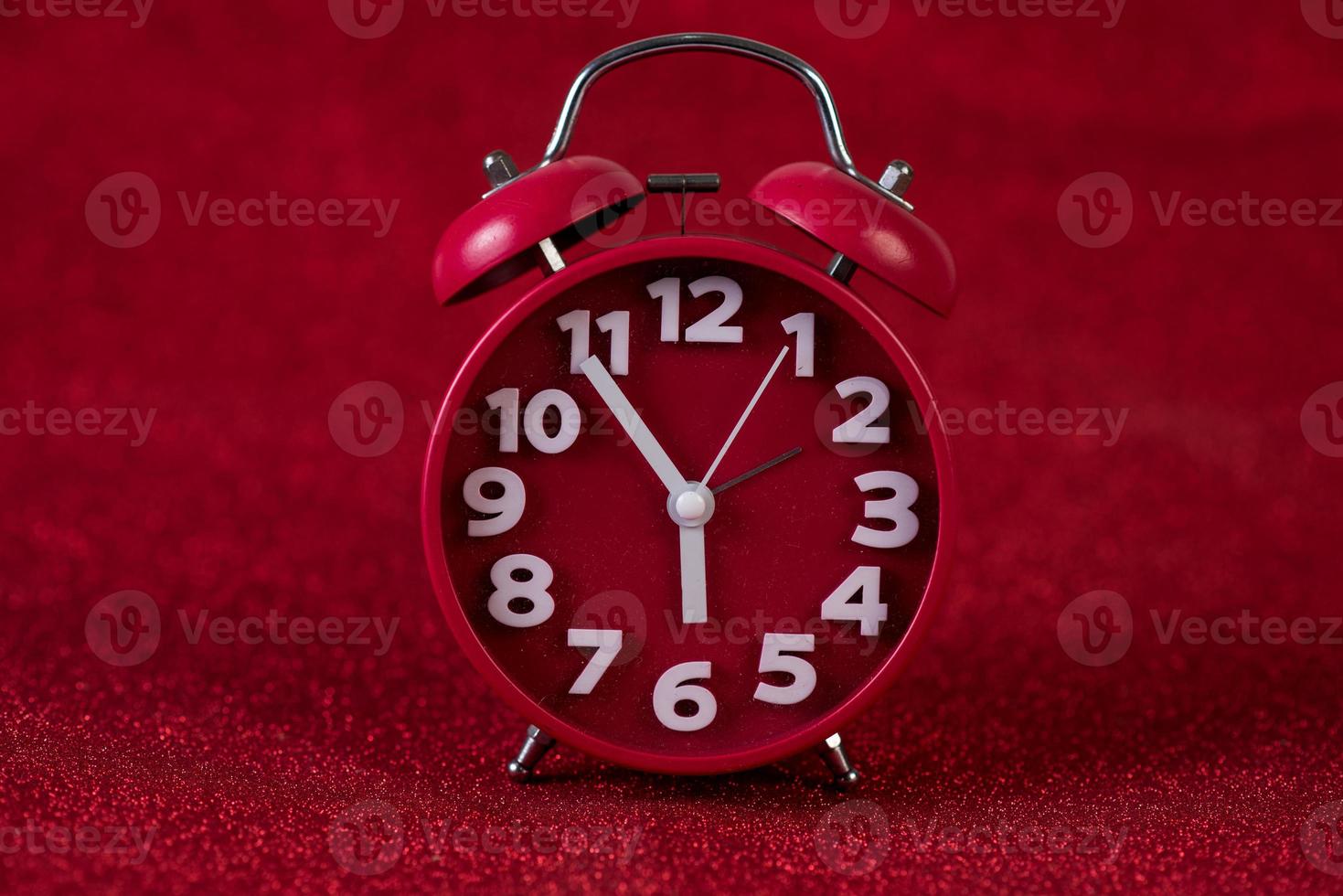rotes Hintergrundbild und schönes rotes Weckerkonzept, Uhrzeit, Datum foto