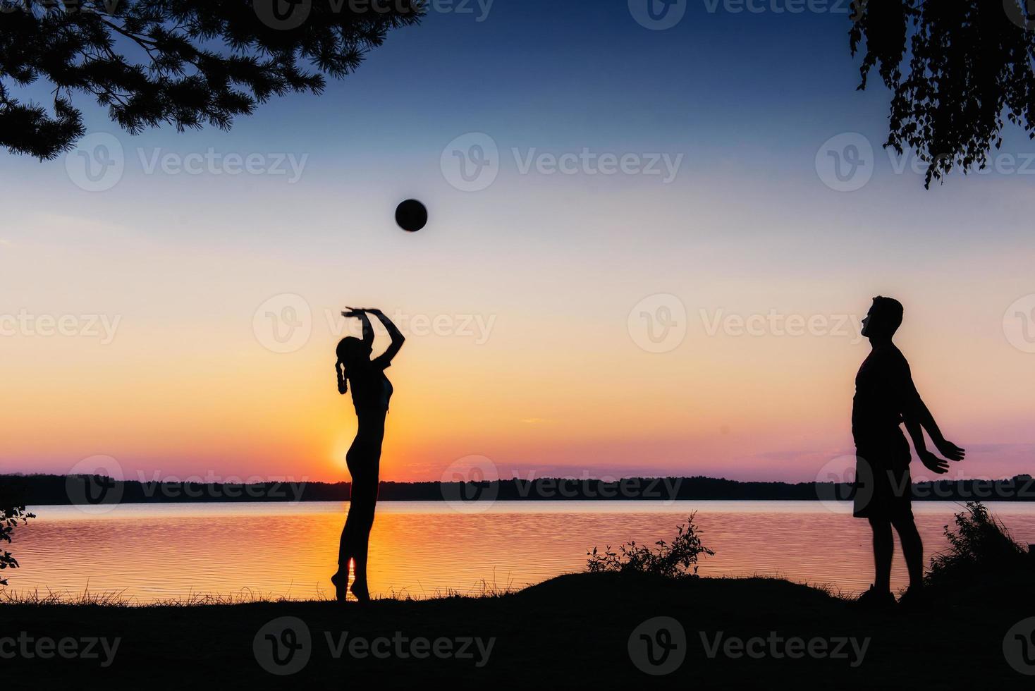 Paar im Spiel bei Sonnenuntergang am See foto