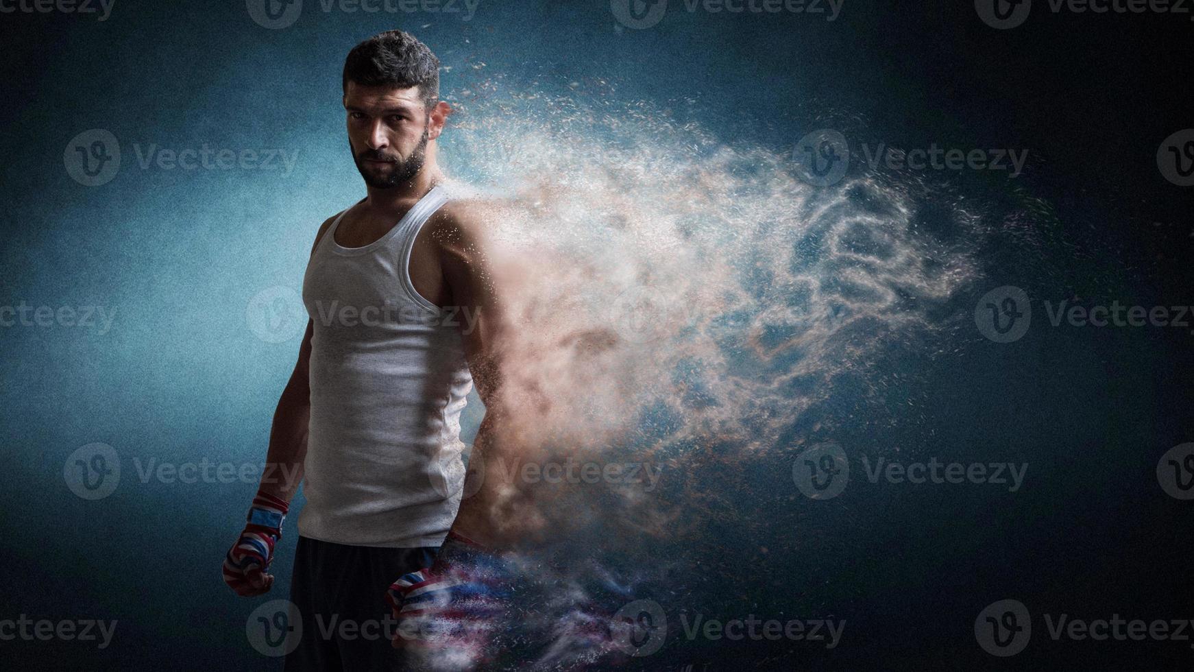 muskulöser männlicher boxer, der über dunklem hintergrund steht, partikeleffekt. foto