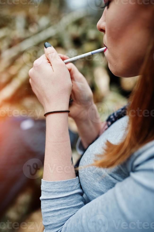 junges mädchen, das draußen zigarette anzündet, hautnah. Konzept der Nikotinsucht von Teenagern. foto