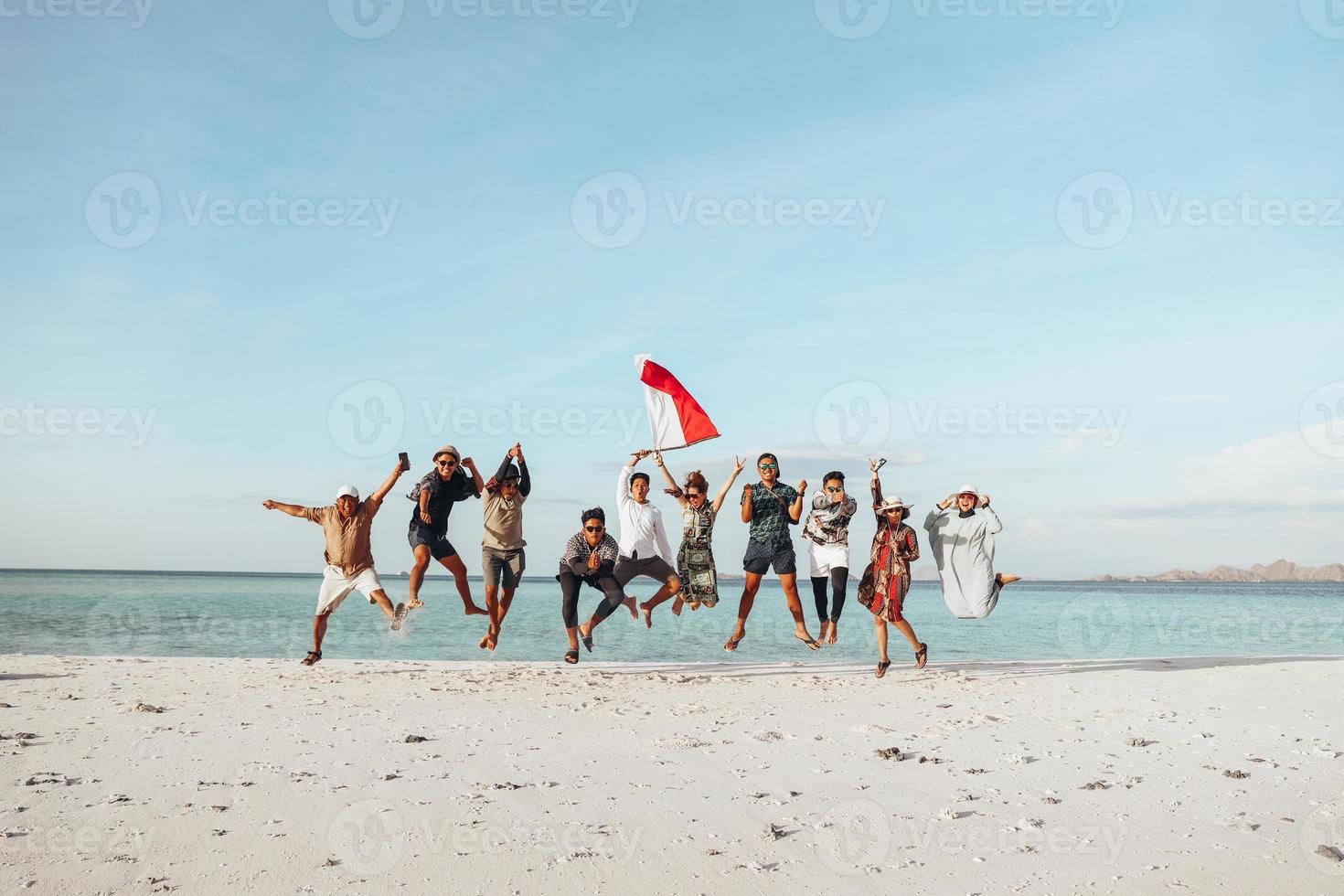 Gruppe von Menschen, die gemeinsam am Strand springen, um den Unabhängigkeitstag Indonesiens zu feiern foto