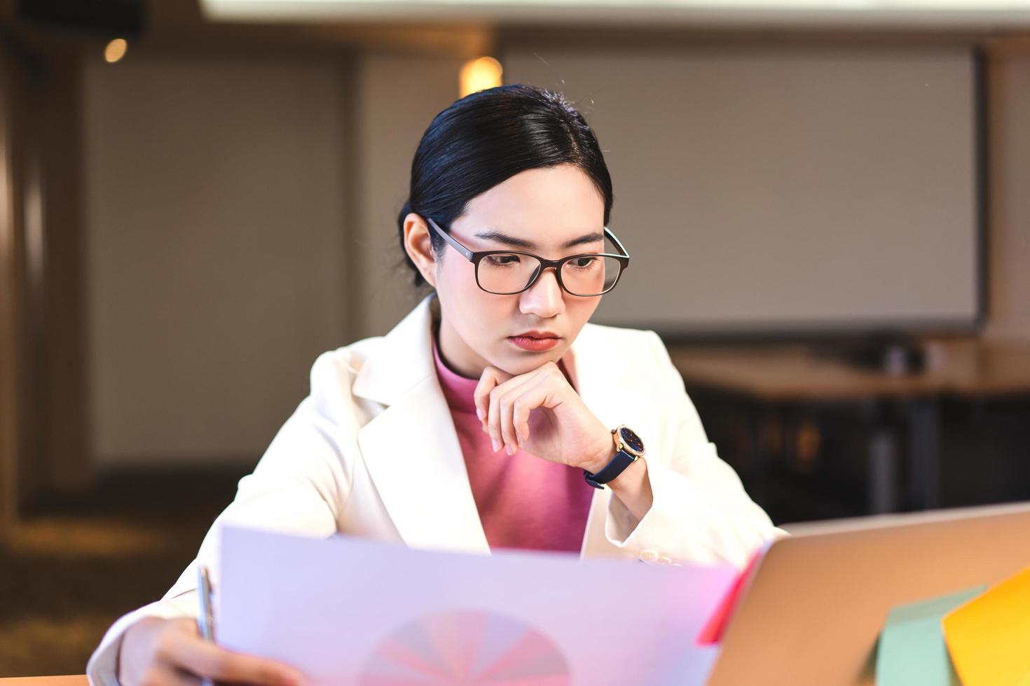 Geschäft arbeitende asiatische Frau mit Brille im Büro. foto