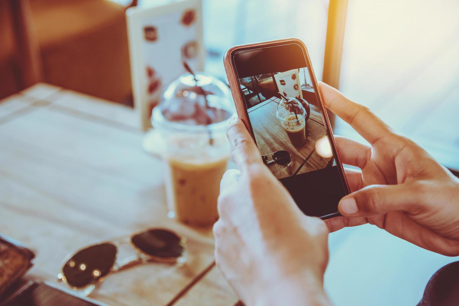 frau, die das handy hält, entspannen sich im urlaub. sitzen, Kaffee trinken foto