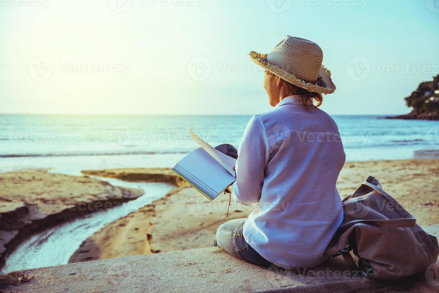 asiatische frau reisen natur. reisen entspannen studieren ein buch lesen und eine notiz schreiben am strand. im Sommer. Thailand foto
