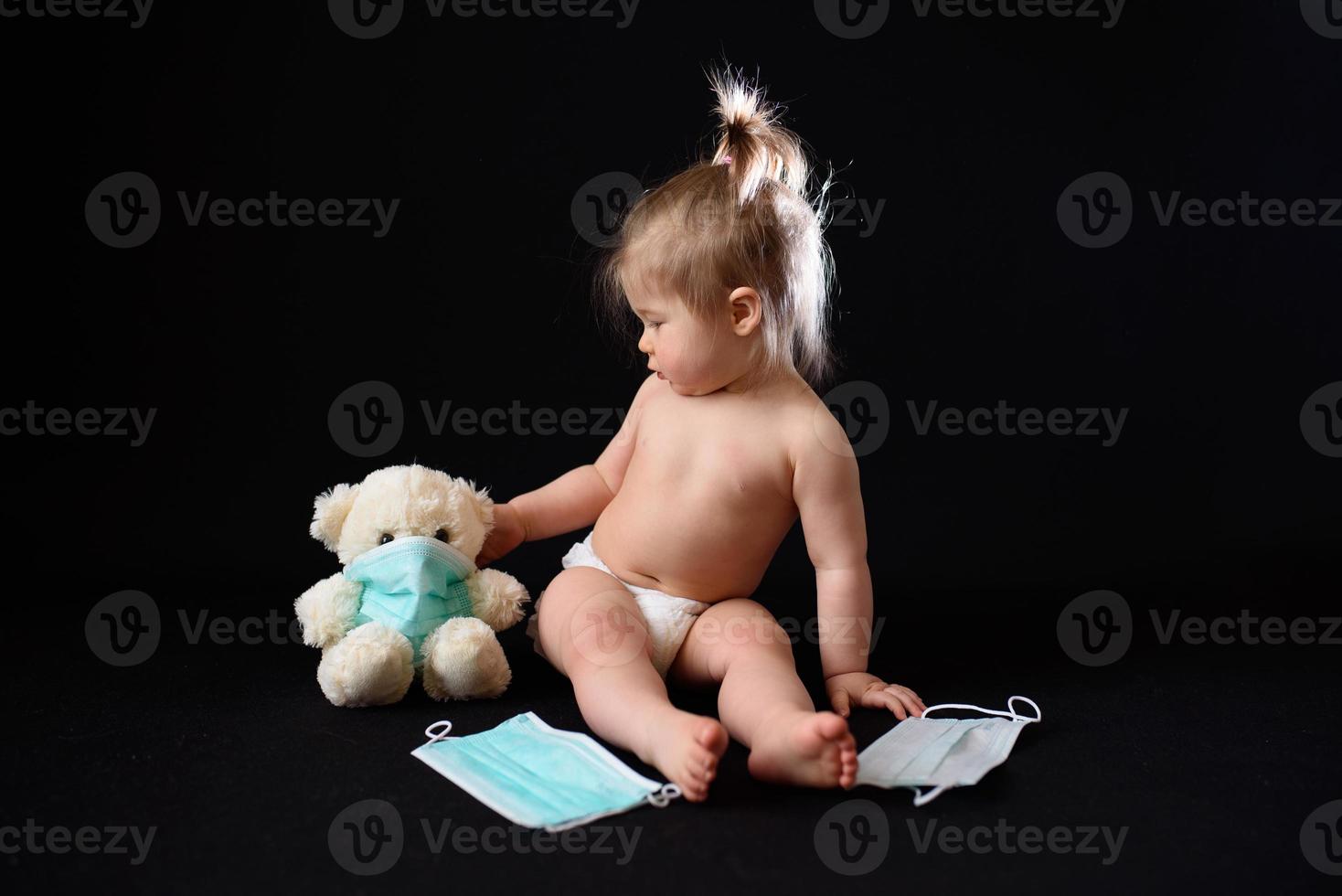 ein kleines kind sitzt neben einem kranken teddybären. das Konzept foto