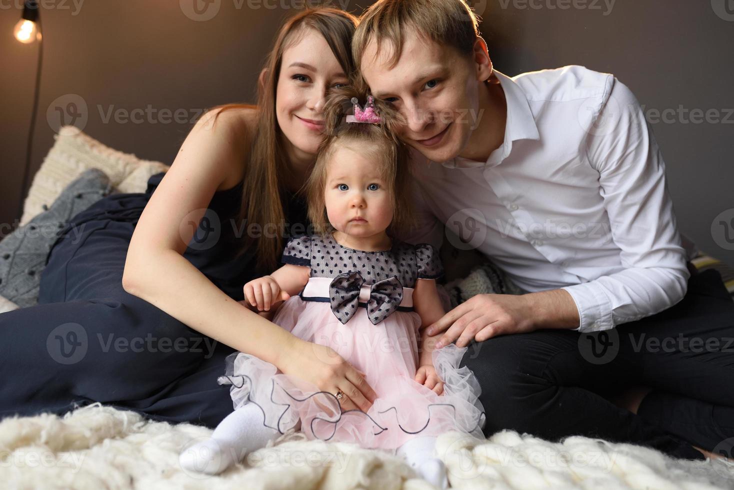 vater mama und ihre kleine einjährige tochter haben vor weihnachten spaß zusammen. foto