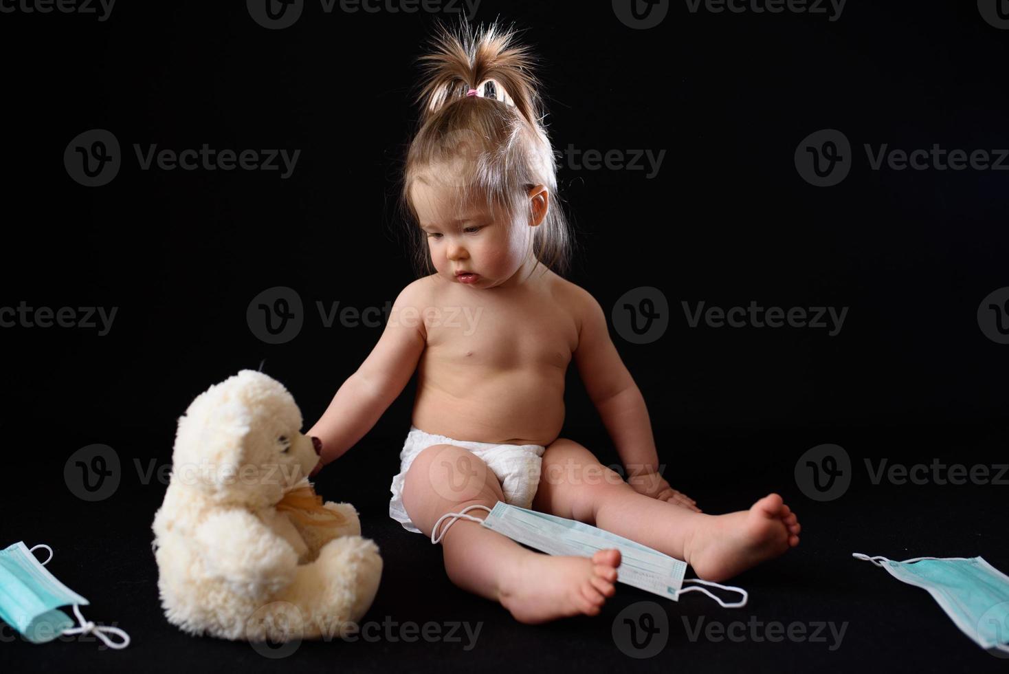 ein kleines kind sitzt neben einem kranken teddybären. das Konzept foto