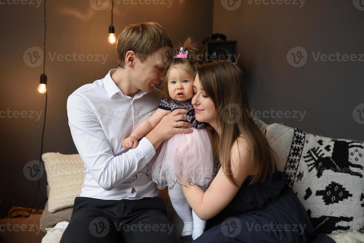 vater mama und ihre kleine einjährige tochter haben vor weihnachten spaß zusammen. foto