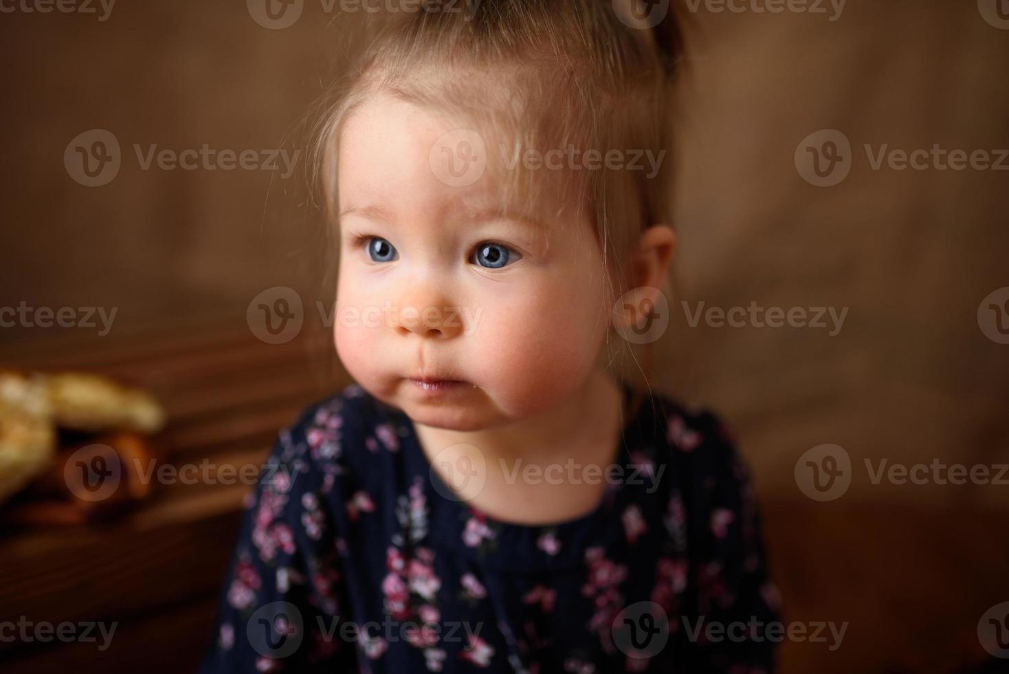 kleines Mädchen in der Küche isst süßes Gebäck. foto